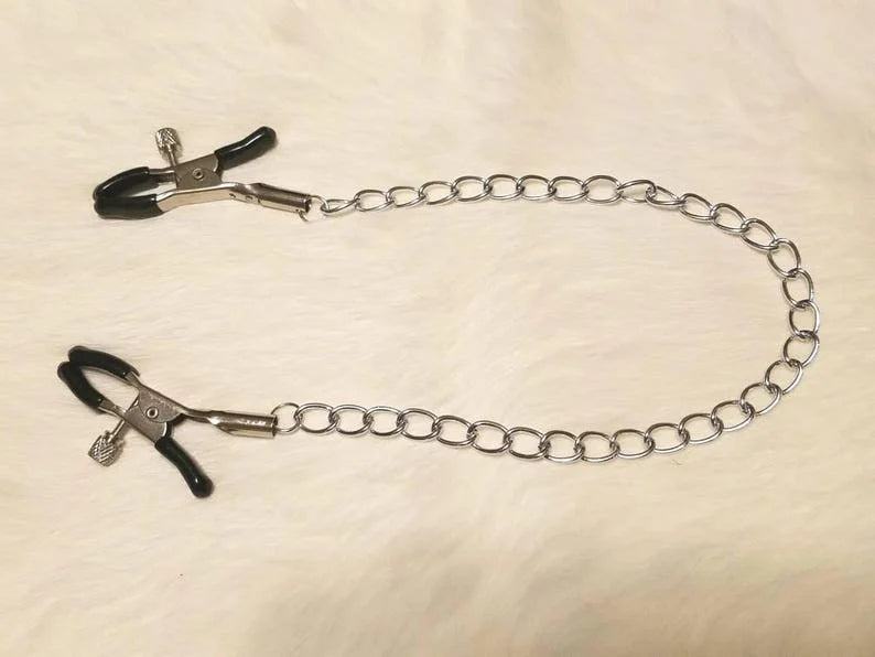 Black nipple clamps laid flat showing chain length