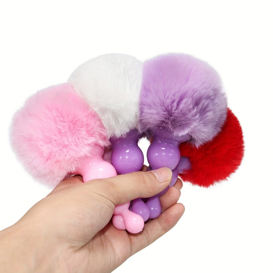 Bunny tail plugs held in hand to show size