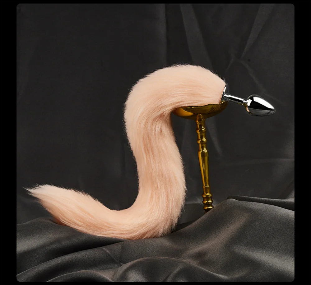 Pastel fox tail butt plug displayed on a stand